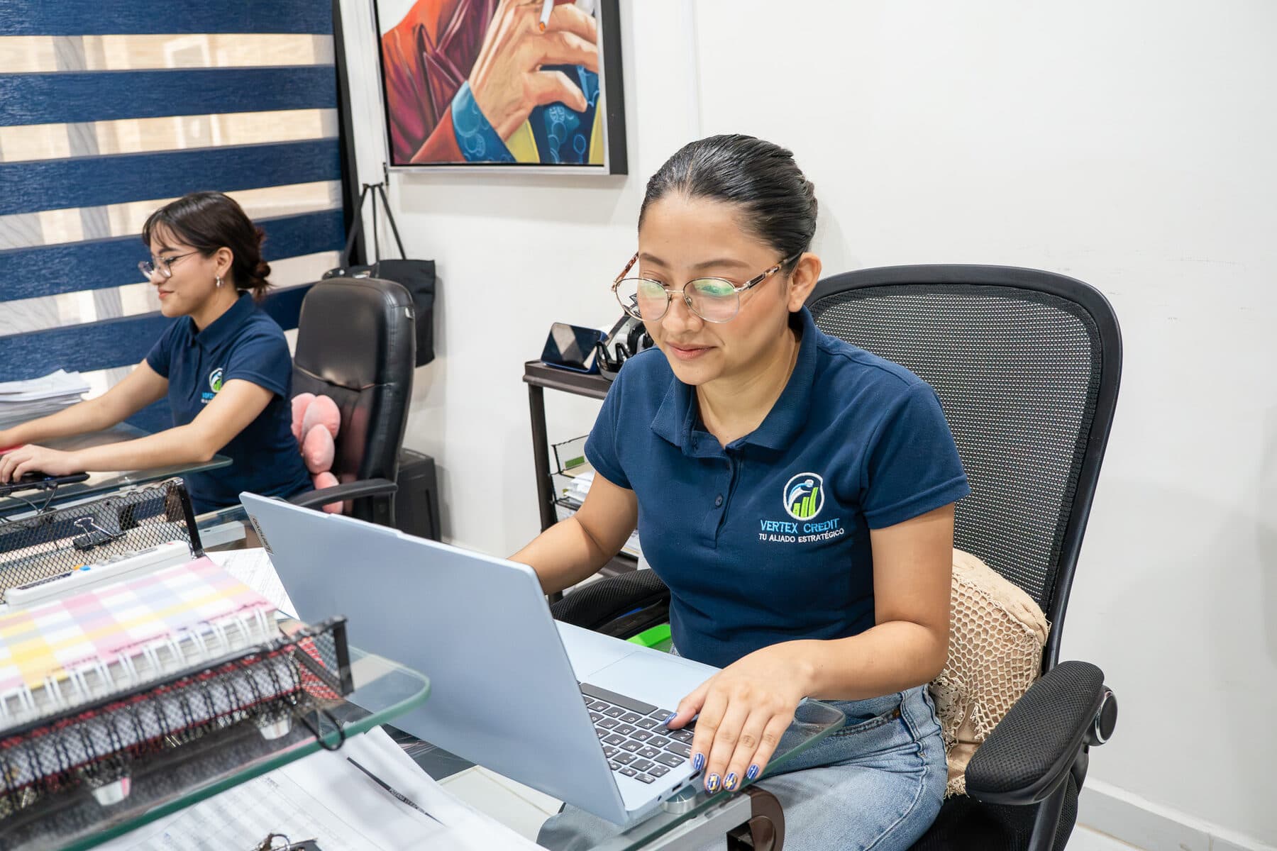 Asesora de Vertex Credit trabajando en su computadora dentro de la oficina.
