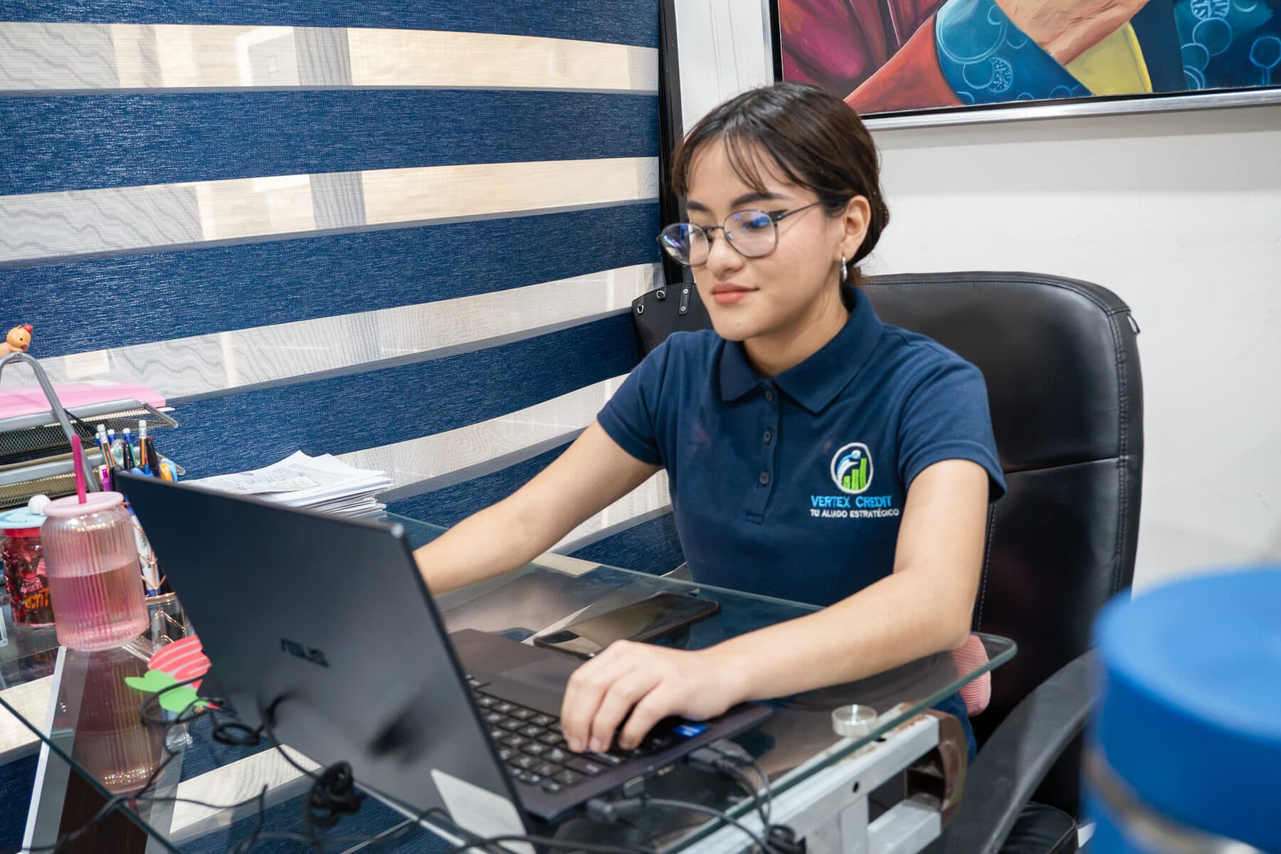 Asesora de Vertex Credit revisando información de un crédito en su computadora.