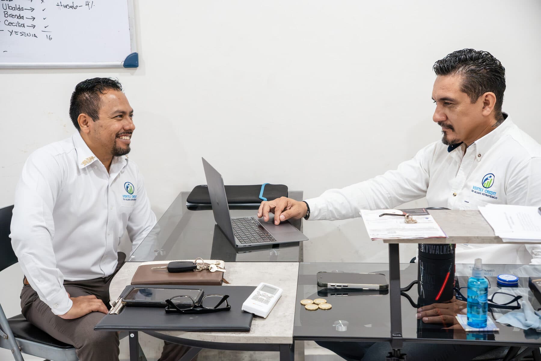 Dos asesores de Vertex Credit revisando juntos una solicitud en la oficina.